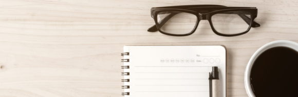 Coffee Pad Glasses And Paperclips On Wood 580X190